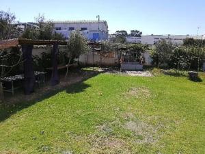 einen Garten mit grünem Rasen und einem Zaun in der Unterkunft Maison des artistes in Tangier