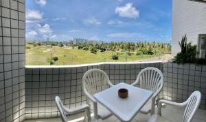 a white table and chairs on a balcony with a window at Flat na Praia de Intermares in Cabedelo