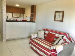 a living room with a couch and a kitchen at Flat na Praia de Intermares in Cabedelo +3 photos