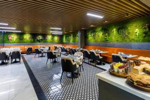 a restaurant with tables and chairs and green walls at Euro Design Hotel in Istanbul
