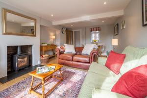 a living room with a couch and a fireplace at Adorable cottage with a log burner in heavenly village - Constable Lodge in Nayland