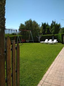 a wooden fence with a park with a playground at El Parque de Isabel in Prado del Rey