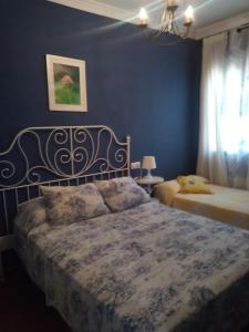 a bedroom with two beds and a blue wall at El Parque de Isabel in Prado del Rey