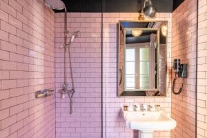 a bathroom with a sink and a mirror at Hôtel Le G (ex Le Genève) in Nice