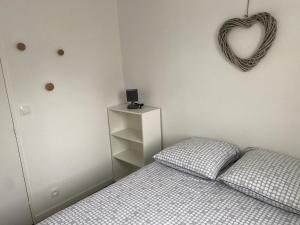 um quarto com uma cama e um sinal de coração na parede em Cabourg T2 cosy avec accès direct plage em Cabourg