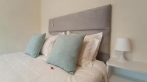 a white bed with blue pillows and a headboard at Beira Rio do Gerês in Geres