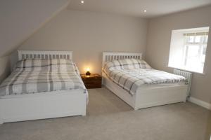 1 Schlafzimmer mit 2 Betten und einem Fenster in der Unterkunft Apartment 4 Tomlinsons Apartments in Rothbury