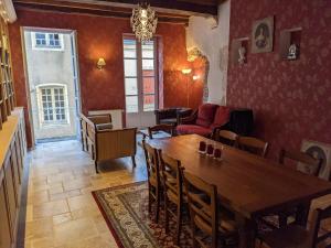 a dining room with a wooden table and chairs at La Licorne - Renovated Townhouse in St Gengoux in Saint-Gengoux-le-National