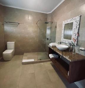 a bathroom with a sink and a toilet and a mirror at Sun Properties and Resort Hotel in Beau Vallon