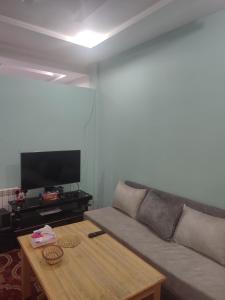 uma sala de estar com um sofá e uma mesa de centro em The good stay 1midelt em Midelt