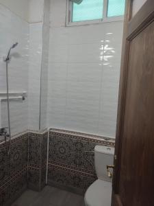 uma casa de banho com um WC e uma cabina de duche em vidro. em The good stay 1midelt em Midelt