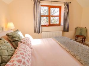 a bedroom with a bed and a window at The Stable in Lincoln