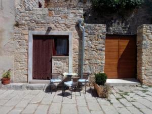 a patio with a table and chairs in front of a building at Sant' Elena Room in Bale