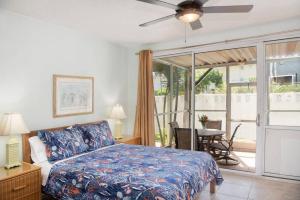 a bedroom with a bed and a table and a window at Beach Living at Island Pine Villas (BLJ) in George Town