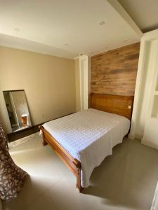 um quarto com uma cama e um espelho em Bartole em Angra dos Reis