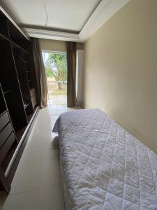 um quarto com uma cama e uma grande janela em Bartole em Angra dos Reis
