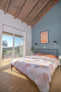 sypialnia z dużym łóżkiem i dużym oknem w obiekcie Ktima Arillas w mieście Arillas