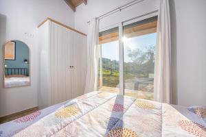 a bedroom with a bed and a large window at Ktima Arillas in Arillas