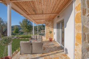 a patio with a wooden ceiling at Ktima Arillas in Arillas