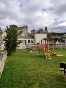 a park with a playground with a castle in the background at La maison de Joëlle in Châteauvieux