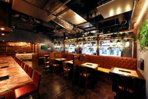 a restaurant with tables and chairs and a bar at Meet Inn Narita in Narita