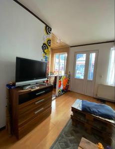 una sala de estar con TV de pantalla plana en una cómoda en Enjoy The Hostel en Batumi
