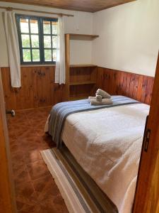 a bedroom with a bed with two towels on it at Casa Vista do Vale in Visconde De Maua