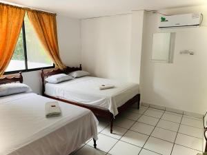 a room with two beds and a window at Hotel Oro Blanco in Atacames