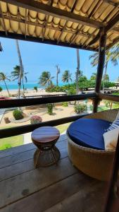a porch with a bed and a table and a view of the beach at Pousada do Paiva in Flecheiras