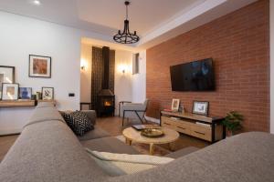 a living room with a couch and a brick wall at Luxury Cottage in Tsaghkadzor by Downtown Inn in Tsaghkadzor