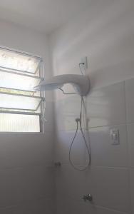a shower head in a bathroom with a window at PONTA das BRILLES Departamento 1 in Nísia Floresta