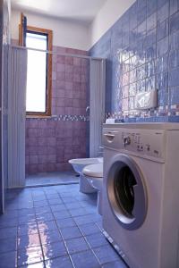 łazienka z toaletą i pralką w obiekcie Appartamenti Marinelli - Santa Maria di Leuca w mieście Leuca
