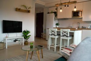 a living room with a table and a kitchen at APARTAMENTO con Jardín en Bádames in Bádames