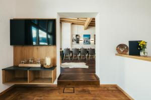 塞爾福斯的住宿－Serfaus Alpensuites，一间设有桌子的用餐室和墙上的电视