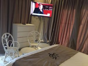 a bedroom with a tv and two chairs and a bed at Villa Jamila -Villa de luxe a Marrakech in Marrakesh