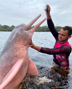 un hombre sosteniendo un gran tiburón en el agua en Anaconda Amazon Island, en Manaus