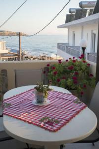einen Tisch mit einer roten und weißen Decke auf dem Balkon in der Unterkunft Psiloritis Elena in Kalamaki