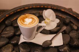a cup of coffee on a plate with chocolate beans at HC6 Boutique Marbella - Adults Only in Marbella
