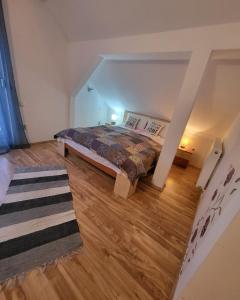 a bedroom with a bed and a wooden floor at House of Julia in Sighişoara