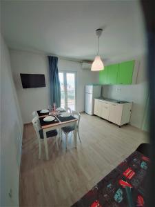 a living room with a table and chairs and a kitchen at Apartman Ariana in Gradac