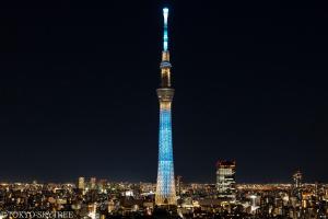 a tall tower lit up in blue at night at Henn na Hotel Tokyo Asakusa Tawaramachi in Tokyo