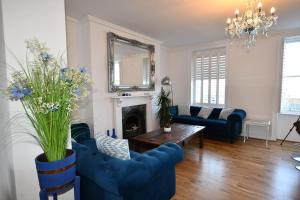 a living room with blue chairs and a fireplace at No. 98 Boutique Hotel in Weymouth