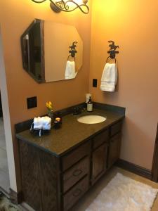 La salle de bains est pourvue d'un lavabo et d'un miroir. dans l'établissement Caldwell Messenger Suites, à Caldwell
