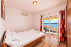 a bedroom with a bed and a view of the ocean at One-Bedroom Apartment Crikvenica near Sea 2 in Dramalj