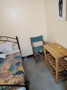 Habitación con cama, mesa y silla en New Kivulini Bed and Breakfast, en Dar es Salaam