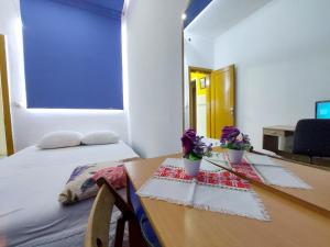 um quarto com uma mesa com flores em At Mejdan Rooms em Saraievo