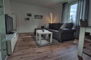 ein Wohnzimmer mit einem Sofa und einem Tisch in der Unterkunft Maisonette privater Zugang Waschmaschine Parkplatz in Hagen