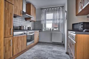 a kitchen with wooden cabinets and a window at Maisonette privater Zugang Waschmaschine Parkplatz in Hagen