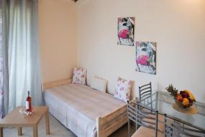 a small bedroom with a bed and a table at Efi Apartments in Agios Gordios