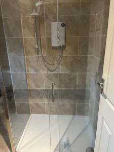 a shower with a glass door in a bathroom at Jasmine House in Newquay